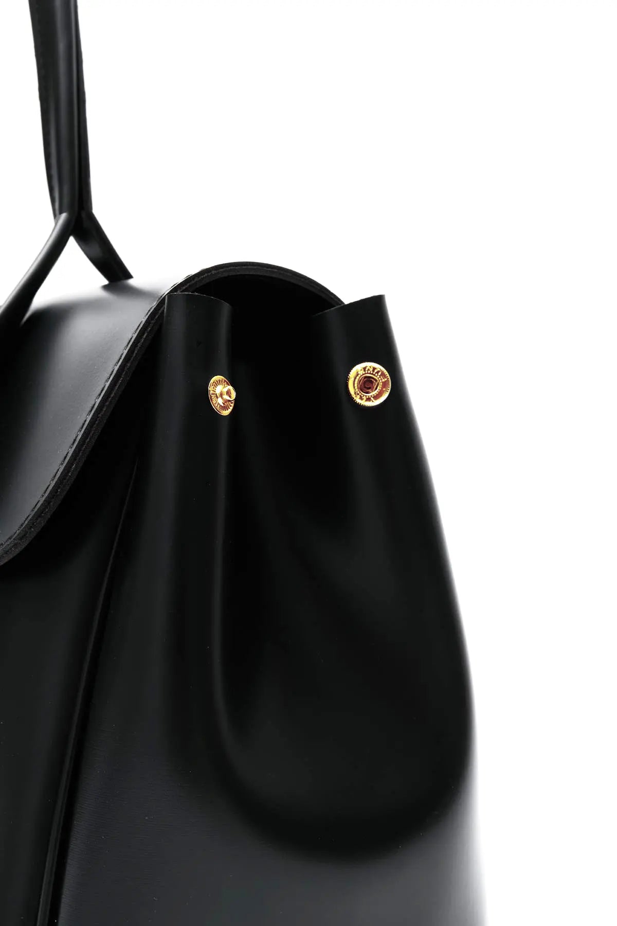 Black handbag with silver hardware on a light gray background. Bag by HBH